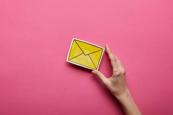 Top view of hand holding yellow message sign on pink background — Stock Photo