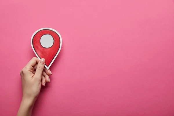Top view of red geolocation in hand on pink background — Stock Photo