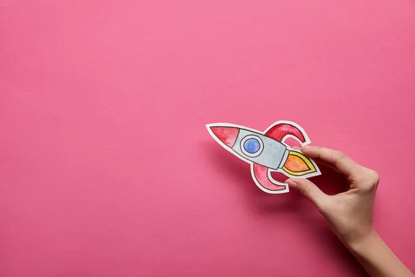 Top view of hand holding rocket on pink background — Stock Photo