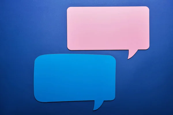 Empty pink and blue speech bubbles on blue background — Stock Photo