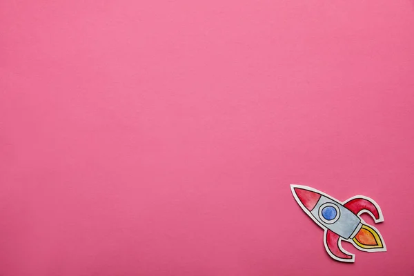 Top view of flying rocket on pink background — Stock Photo