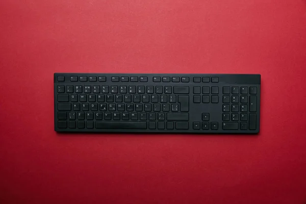 Vue du dessus du clavier d'ordinateur noir sur fond rouge — Photo de stock