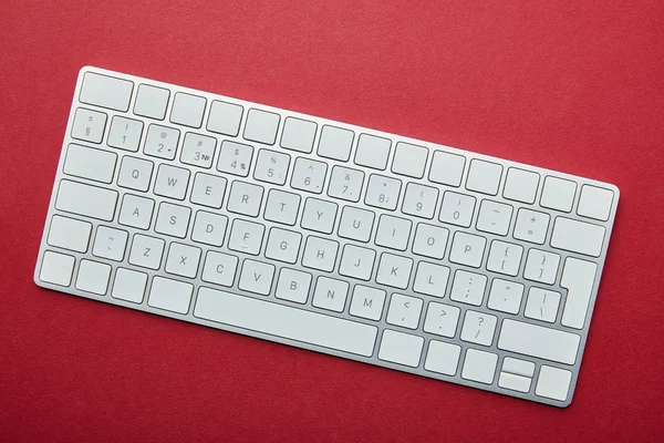 Vue du dessus du clavier d'ordinateur blanc sur fond rouge — Photo de stock