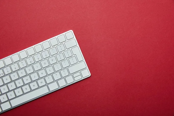 Visão superior do teclado do computador branco no fundo vermelho com espaço de cópia — Fotografia de Stock