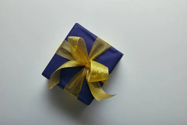 Top view of wrapped present with yellow ribbon on grey background — Stock Photo