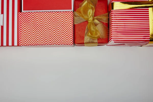 Top view of presents wrapped in colourful wrapping paper on grey background — Stock Photo