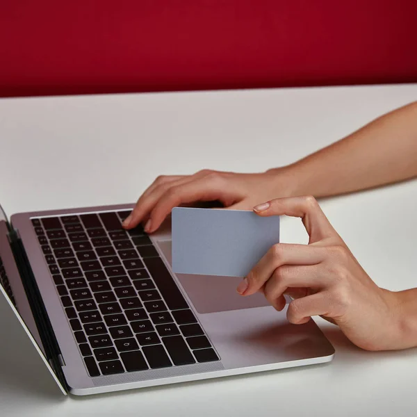 Vista cortada da mulher segurando cartão de crédito na mão e usando laptop — Fotografia de Stock