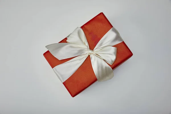 Vista superior de regalo envuelto con cinta de satén blanco aislado sobre fondo gris - foto de stock