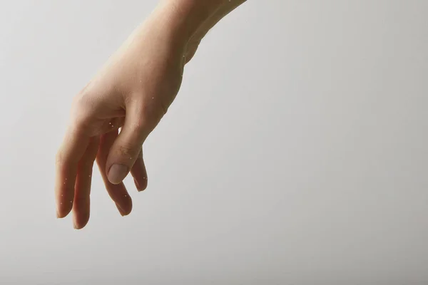 Primer plano de la mujer con la mano en agua pura, aislado en gris con espacio de copia - foto de stock