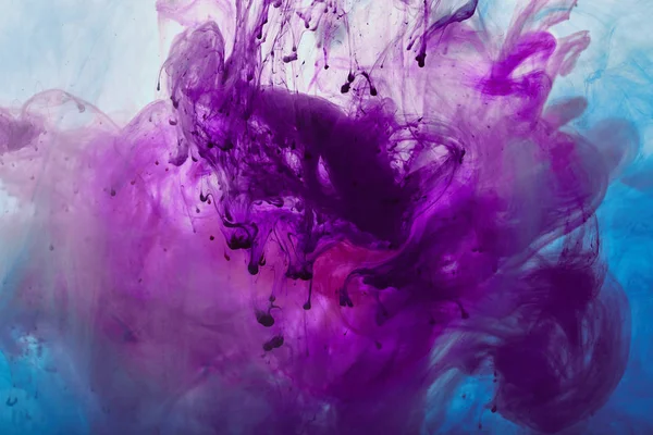 Close up view of purple and blue mixing paint swirls — Stock Photo