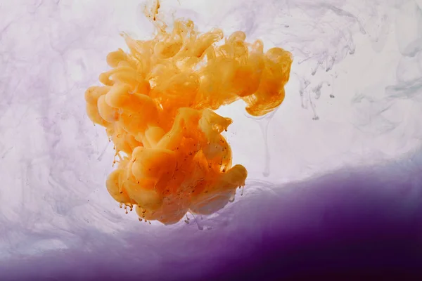 Close up view of purple paint swirls and orange splash — Stock Photo