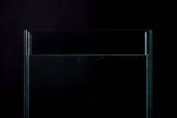Empty aquarium with pure water isolated on black — Stock Photo