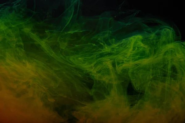 Абстрактный фон с зелеными и оранжевыми вихрями краски — стоковое фото