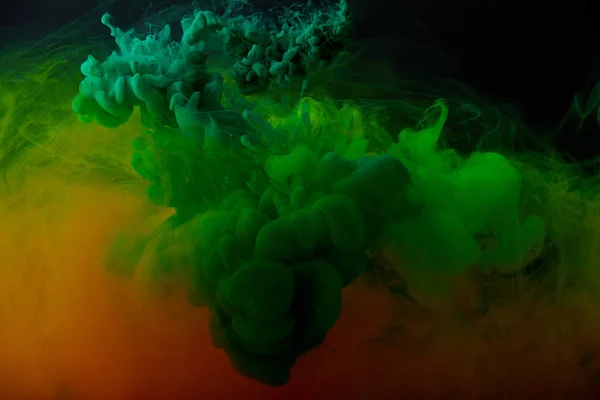 Абстрактный фон с зелеными и оранжевыми брызгами краски — стоковое фото