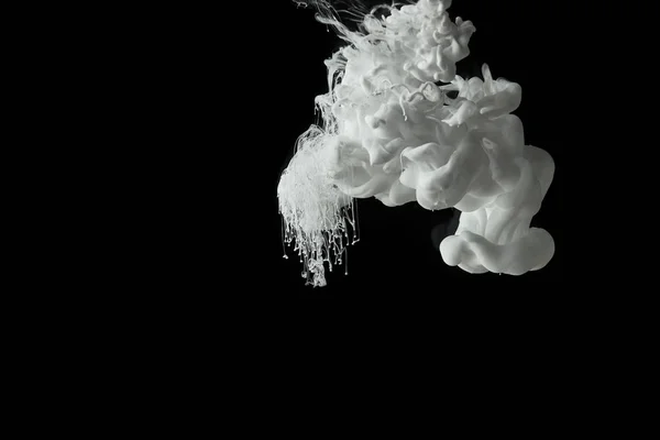 White paint splash flowing in water on black background — Stock Photo