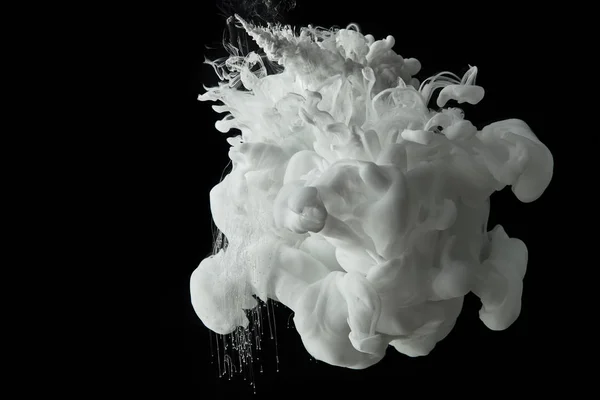 White splash of paint flowing in water on black background — Stock Photo