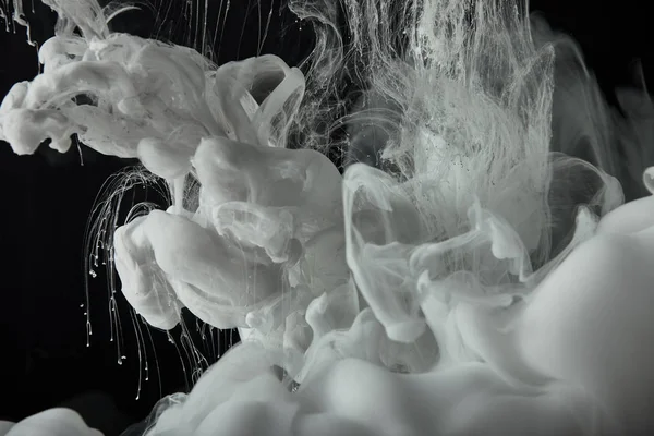 Peinture blanche éclaboussure dans l'eau sur fond noir — Photo de stock