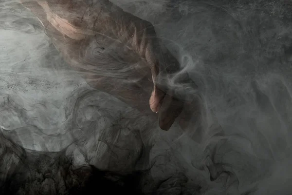 Vue partielle de la main masculine en fumée grise — Photo de stock