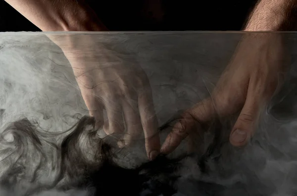 Cropped view of tender couple touching fingers in water with black paint — Stock Photo