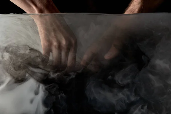 Partial view of tender couple touching fingers in water with black paint — Stock Photo