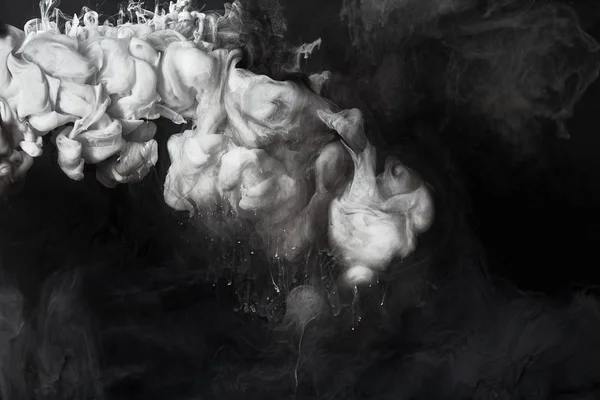 Абстрактні сірі бризки фарби на чорному фоні — стокове фото
