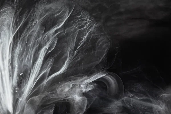 Resumo redemoinhos fluidos de tinta cinzenta sobre fundo preto — Fotografia de Stock