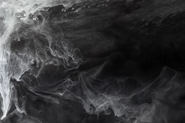 Abstraits tourbillons fluides de peinture grise sur fond noir — Photo de stock
