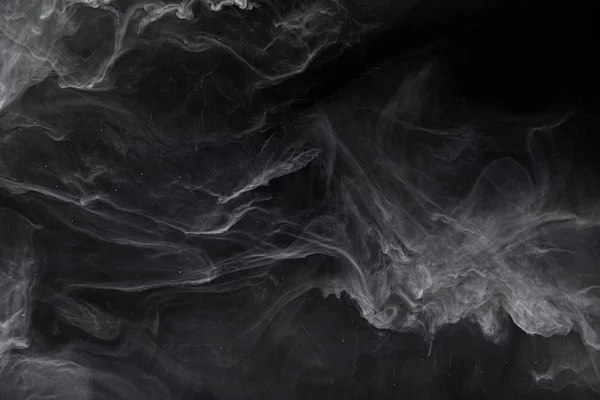 Abstract swirls of grey paint on black background — Stock Photo
