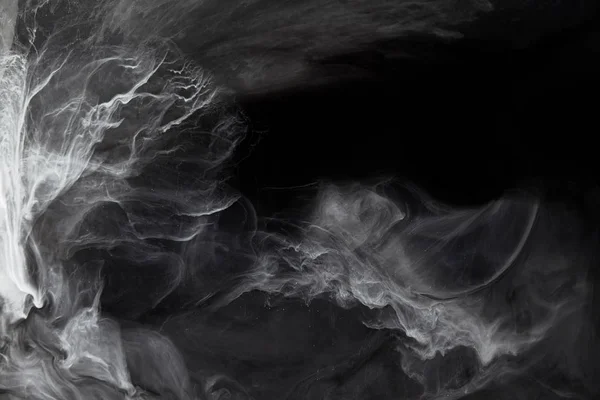 Abstract swirls of grey paint on black background — Stock Photo