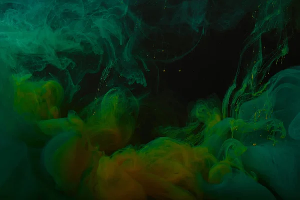 Vue rapprochée du fond abstrait avec des tourbillons de peinture vert et orange — Photo de stock