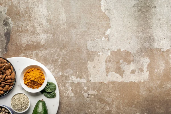 Vue de dessus des amandes, graines de sésame et curcuma sur fond rustique texturé avec espace de copie — Photo de stock