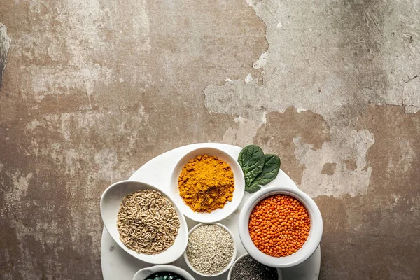 Vue de dessus des lentilles rouges, des gruaux d'avoine et du curcuma sur fond rustique texturé avec espace de copie — Photo de stock