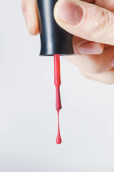 Vista parcial del cepillo de mujer con esmalte de uñas rojo aislado en gris - foto de stock