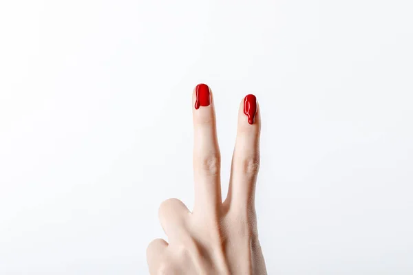 Vista cortada da mulher mostrando sinal de paz com esmalte vermelho gotejamento isolado em cinza — Fotografia de Stock