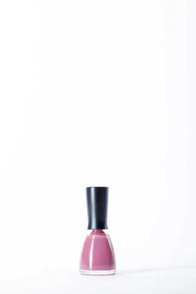 Bottle of shiny pink nail polish on white — Stock Photo