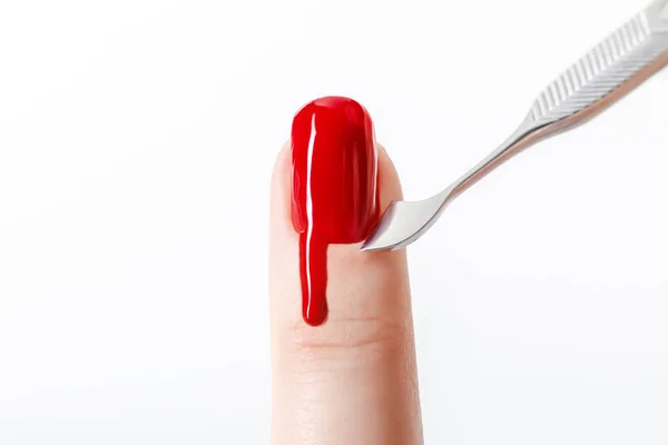 Vue recadrée de la femme à l'aide d'un instrument de manucure sur ongle avec vernis à ongles rouge isolé sur blanc — Photo de stock