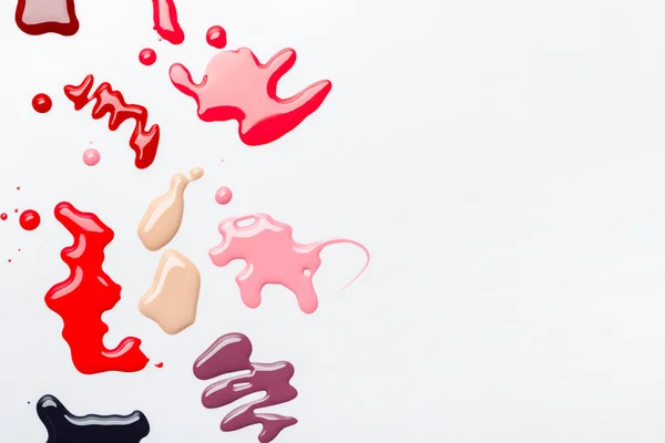 Top view of abstract spills of nail polish with multicolored drops isolated on grey — Stock Photo