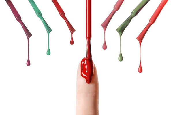 Gota desordenada de esmalte de uñas rojo goteando en uñas aisladas en blanco - foto de stock