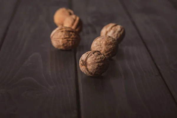 Close up view of walnuts on dark wooden tabletop — Stock Photo