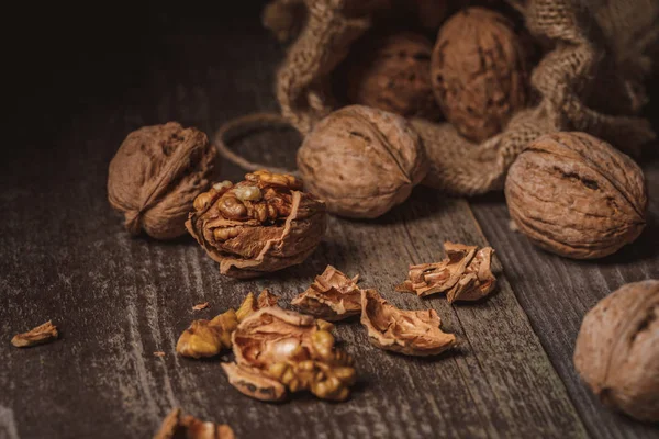 Vista de cerca de las nueces en saco sobre fondo de madera - foto de stock