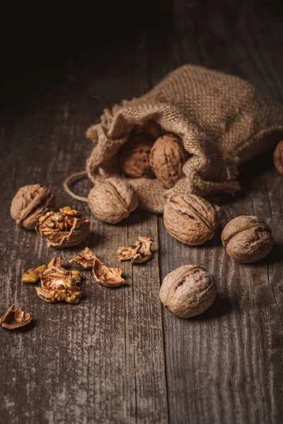 Vista de cerca de las nueces en saco sobre fondo de madera - foto de stock