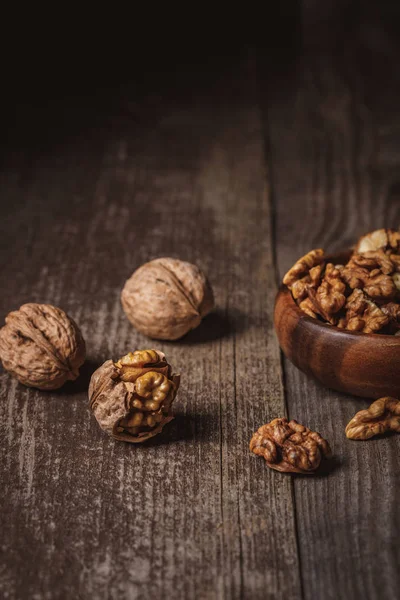 Close up view of walnuts in bowl on wooden surface — Stock Photo