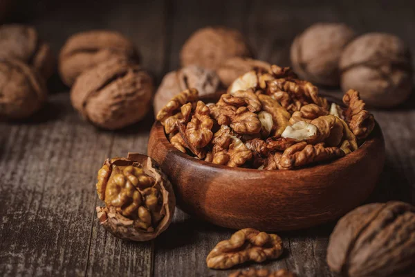 Close up view of walnuts in bowl on wooden surface — Stock Photo