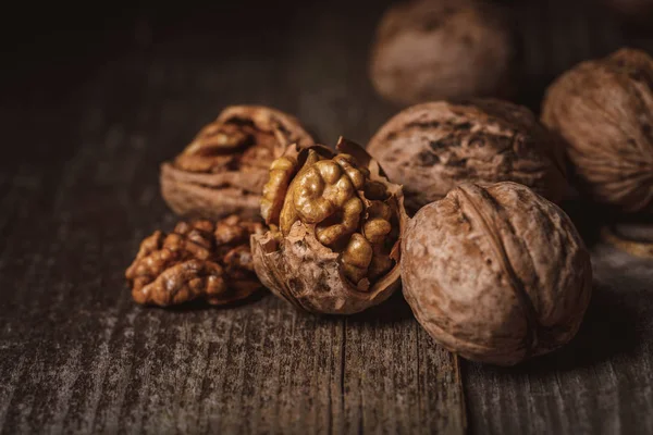 Close up view of shelled and whole walnuts on wooden tabletop — Stock Photo
