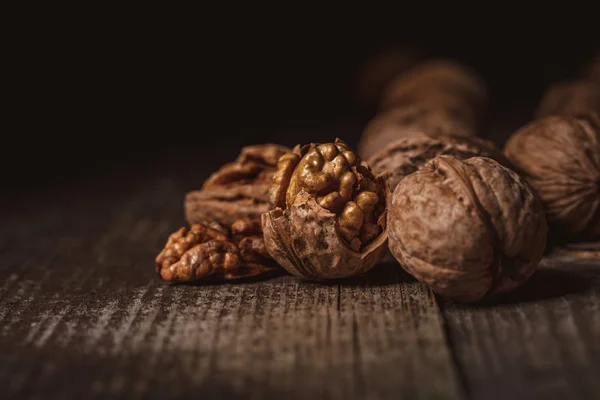 Close up view of shelled and whole walnuts on wooden tabletop — Stock Photo