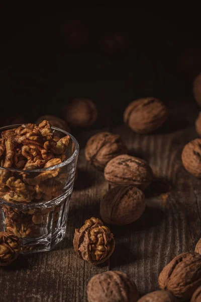 Close up view of shelled walnuts in glass on wooden surface — Stock Photo