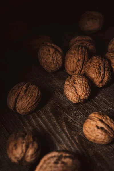 Close up view of walnuts in husk on wooden table — Stock Photo