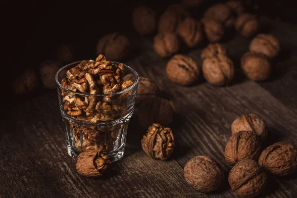 Close up view of tasty shelled walnuts in glass on wooden table — Stock Photo