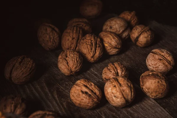 Close up view of walnuts in husk on wooden table — Stock Photo