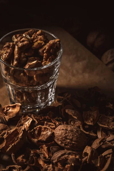 Close up view of shelled walnuts in glass on black backdrop — Stock Photo
